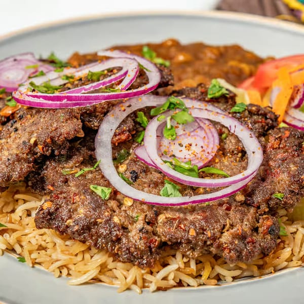 Chaska Kabob & Rice's Pakistani street food: spicy kabobs with red onions, cilantro, and rice.